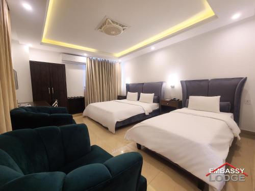 伊斯兰堡Embassy Lodge的酒店客房,设有两张床和一张沙发