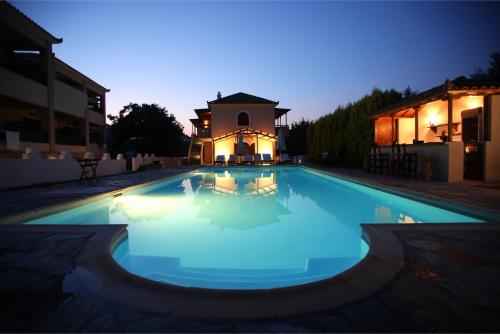 斯科派洛斯太阳住宿酒店的一座游泳池,位于一座建筑的后面