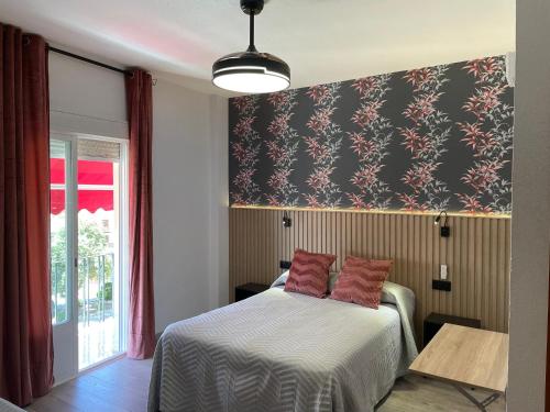 Zalamea de la SerenaHostal Calderón de la Barca的一间卧室配有一张黑色和红色壁纸的床