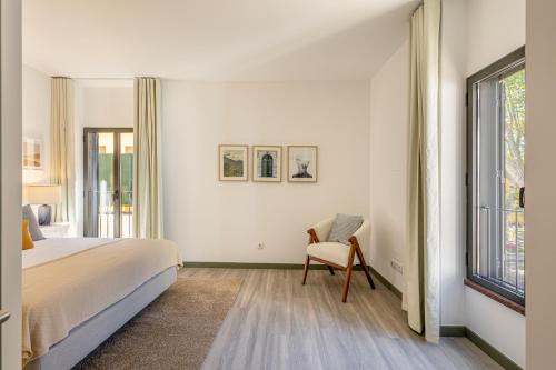 马希库Fort Bay Suite Apartments的卧室配有床、椅子和窗户。