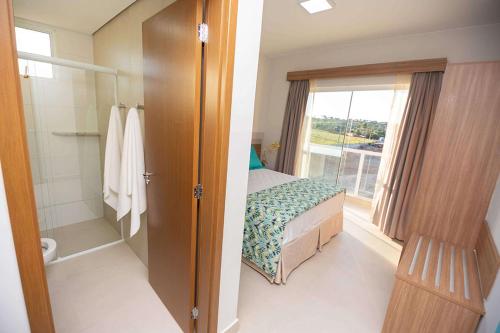 卡达斯诺瓦斯Ilhas do Lago Eco Resort的一间卧室配有一张床,浴室设有窗户
