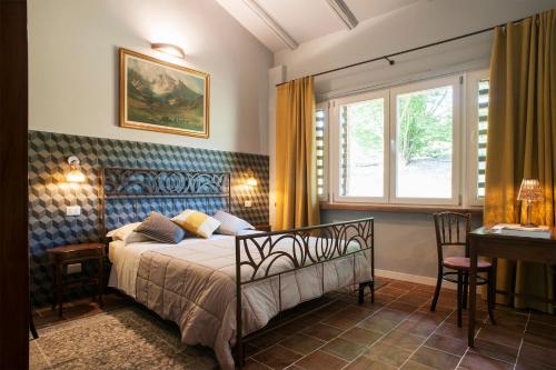卡拉曼德拉纳La Giribaldina Winery & Farmhouse的一间卧室配有一张床、一张书桌和一个窗户。