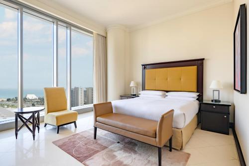 多哈多哈市中心马奎斯万豪酒店的一间卧室配有一张床、一张桌子和一把椅子