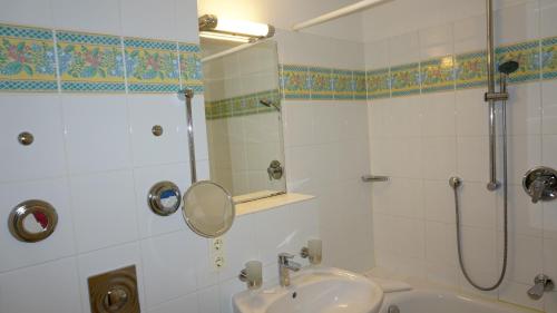 赛巴特班森kleiner Seehof - FeWo 01的浴室配有盥洗盆和带镜子的淋浴