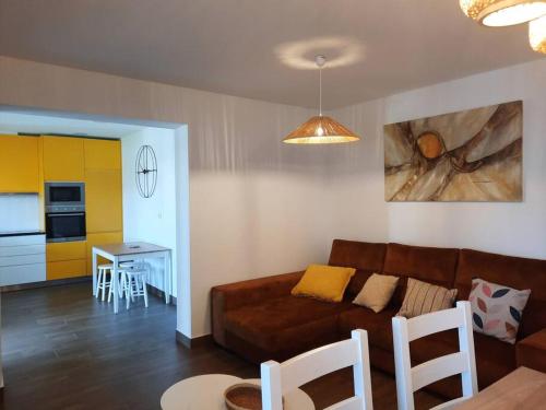 孔波尔塔Sado House 2的一间带棕色沙发的客厅和一间厨房