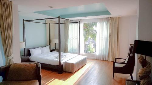 佛丕Nirvana Hua Hin Pool Villa的一间卧室设有一张床和一个大窗户