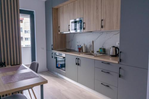 布加勒斯特Your New and Modern Home的厨房配有白色橱柜、水槽和桌子