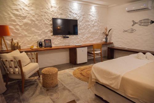 伊卡莱Moriá Eco Lodge的一间卧室配有一张床和一张书桌及电视