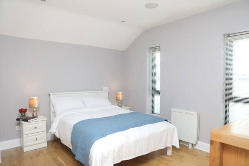 福克斯福德Luxury Three Bedroom Apartment Foxford County Mayo的一间白色卧室,配有床和2个窗户