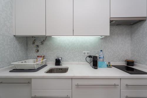 里斯本BeGuest Benfica Modern Flat的厨房柜台配有水槽和白色橱柜