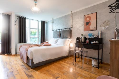 米兰Città Studi Suites - Top Collection的一间卧室配有一张床、一张桌子和一张四柱床。