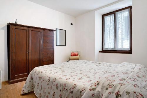 滕诺Appartamento nel cuore di Tenno的一间卧室配有一张床和一个木制橱柜