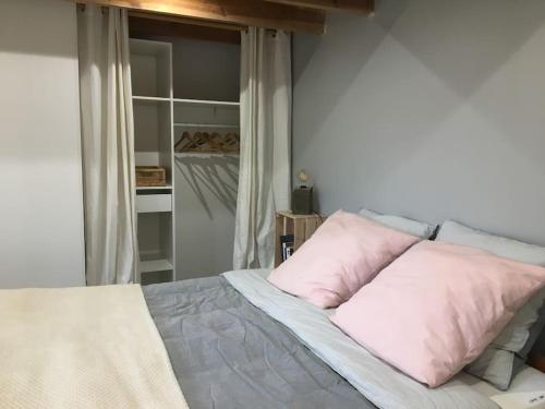 PrigonrieuxLa remise d'Angèle的一间卧室配有带粉红色枕头的床。