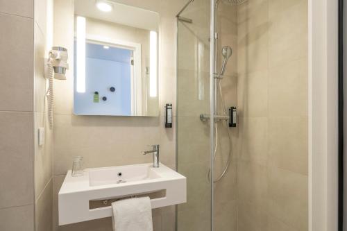 梅赫伦B&B HOTEL Mechelen的一间带水槽和淋浴的浴室