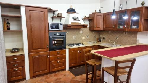 蒙德罗Villa Sinforosa - Mondello的厨房配有木制橱柜和炉灶烤箱。