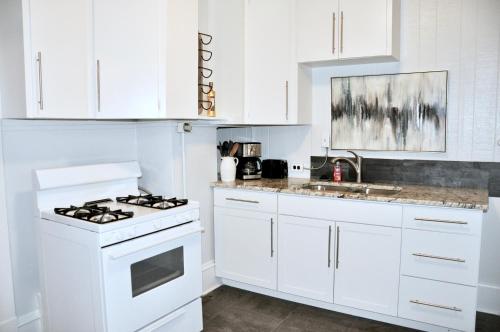 拉皮德城Downtown 1 Bedroom Charmer - Walk, Bike, Enjoy!!的白色的厨房配有炉灶和水槽