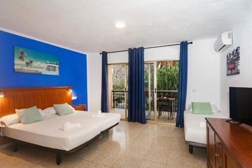贝尼多姆APARTAMENTOS PALASIET的卧室配有一张白色大床和电视。