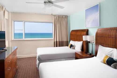迈阿密海滩Sherry Frontenac Oceanfront的酒店客房设有两张床和窗户。