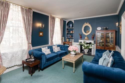 巴斯Abbey Mews in the heart of Bath的蓝色的客厅配有两张蓝色的沙发和一张桌子