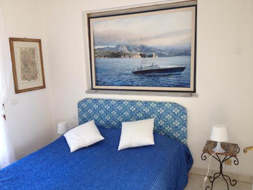 卡波利韦里Villa mit Whirlpool und phantastischer Aussicht的一间卧室配有一张蓝色的床和一幅船画