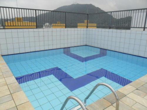 瓜鲁雅Dom Pedro 26的一座大型游泳池,位于大楼内,铺有蓝色瓷砖