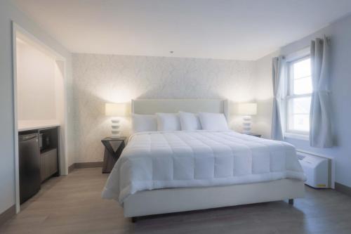 韦斯特伯鲁韦斯特伯勒旅舍的白色的卧室设有一张白色大床和一个窗户。