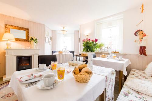 永斯多夫永斯多夫阳光民宿的一间设有白色桌子和壁炉的用餐室