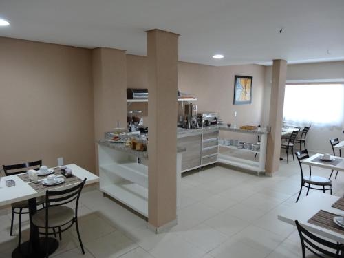 大坎普Cerrado Hotel LTDA的厨房以及带桌椅的用餐室。