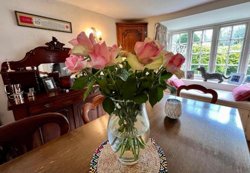 法纳姆Vine Cottage的一张桌子上一束粉红色玫瑰花