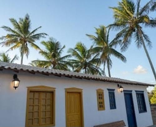 瓜拉派瑞Pousada Vila Sol Maior的一座棕榈树成荫的白色房子