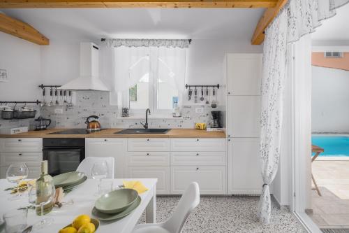 佩罗杰Spacious holiday house in Istria的厨房配有白色橱柜和一张带盘子的桌子