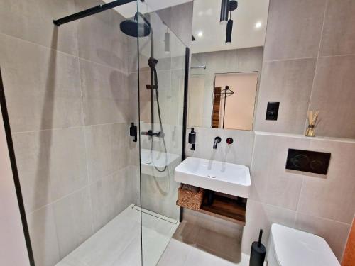马汀Penzion San Martin的一间带玻璃淋浴和水槽的浴室