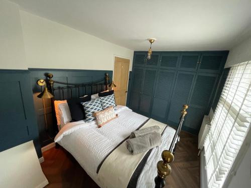 布里奇诺斯The Railway Cottage Bridgnorth的一间卧室配有一张大床和蓝色床头板