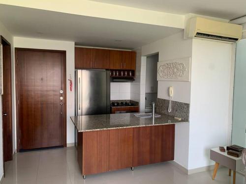 卡塔赫纳Apartamento morros 922的厨房配有木制橱柜和不锈钢冰箱。