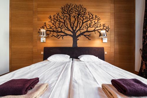 塔林AirHome - Tree Spirit的一张白色的大床,墙上有一棵树