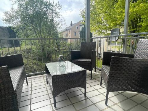 开姆尼茨Modernes Apartment in Chemnitz的阳台的天井配有椅子和玻璃桌