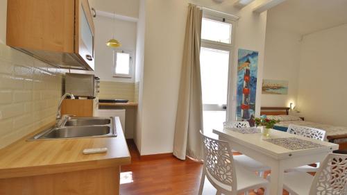 莫诺波利Casa Levante a 75 mt dalla spiaggia的厨房配有水槽和桌椅