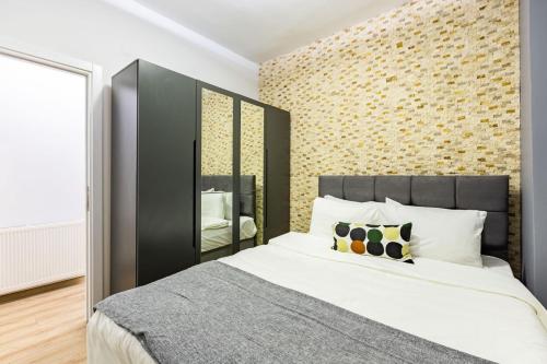 伊斯坦布尔Distinguished Flat with Backyard in Sisli的一间卧室设有一张大床和砖墙