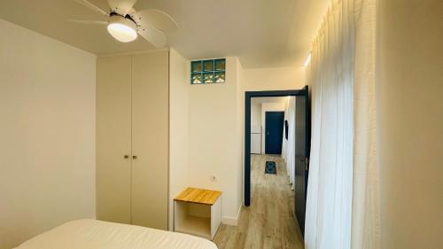 巴达霍斯Apartamentos BRAVO MURILLO con garaje en centro histórico的一间卧室配有一张床、一张桌子和吊扇