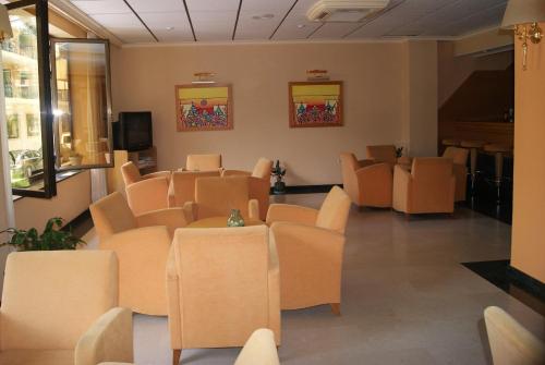 贝尼多姆罗莎贝尔酒店的一间配备有橙色椅子和电视的等候室