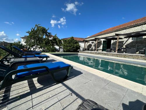 杜罗河畔瓦伦萨Quinta da Casa Cimeira, Guest House, Wines & Food的游泳池旁的一排躺椅