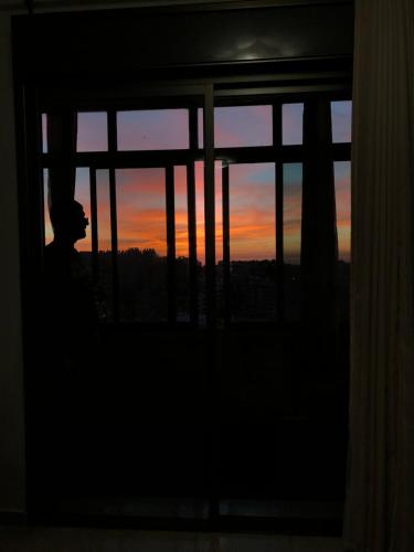 拉马拉King castle的日落时从窗口望出去的人
