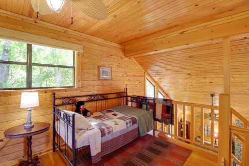 芒廷维尤Roomy Riverfront Trout Valley Cabin with Porch!的小木屋内一间卧室,配有一张床