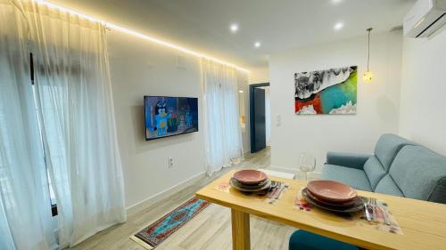 巴达霍斯Apartamentos BRAVO MURILLO con garaje en centro histórico的客厅配有蓝色的沙发和桌子
