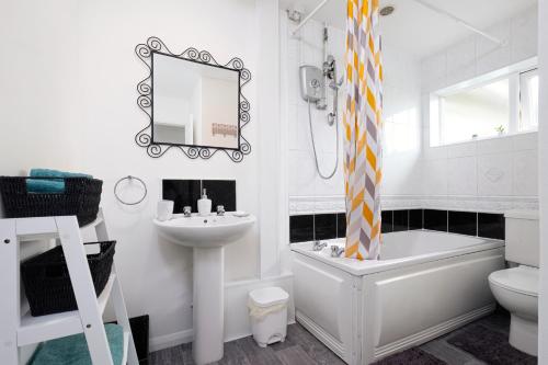 彼得伯勒6bed Perfect stay! Contractors welcome!的白色的浴室设有水槽、浴缸和卫生间。