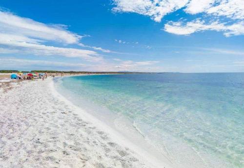 托里格兰德casa vacanza Il Delfino的一片白色沙滩和蓝色的海水