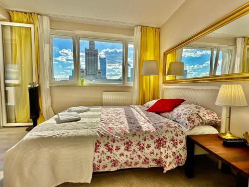 华沙Super GOLD Centrum 2x Metro WiFi 600 Mb/s Netflix HBO AppleTV的一间卧室配有一张带红色枕头的床和一扇窗户