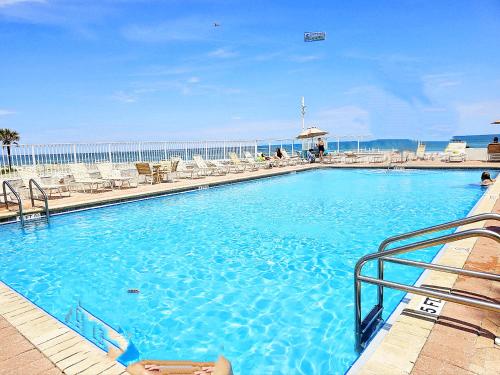 代托纳海滩Oceanfront Escape With Balcony and heated salt water pool!的一个带椅子和乙 ⁇ 的蓝色大游泳池