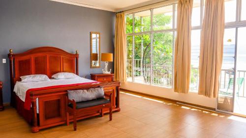 El CongoQuinta Sunset, Lago de Coatepeque的一间卧室设有一张床和一个大窗户