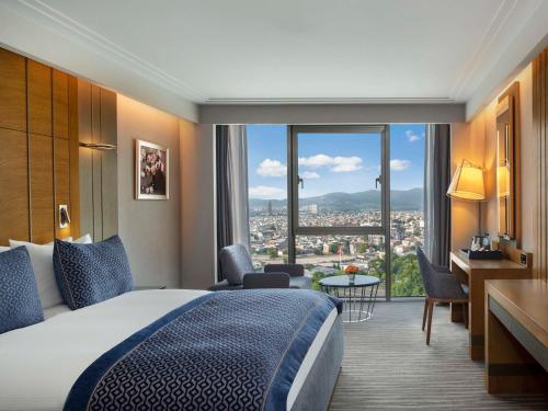 伯萨Mövenpick Hotel & Thermal Spa Bursa的酒店客房设有一张床和一个大窗户